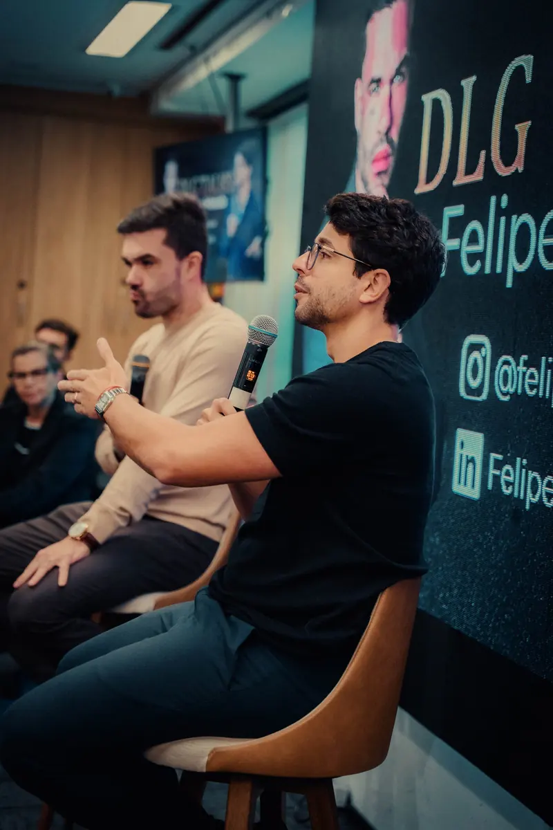 Convidado Felipe Hatab falando ao microfone em painel do DLG Talks