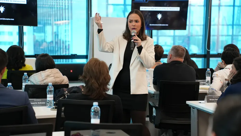 Turma de empresários da saúde em sala de mentoria da 5G Company, com a mentora Caroline Mota ao quadro