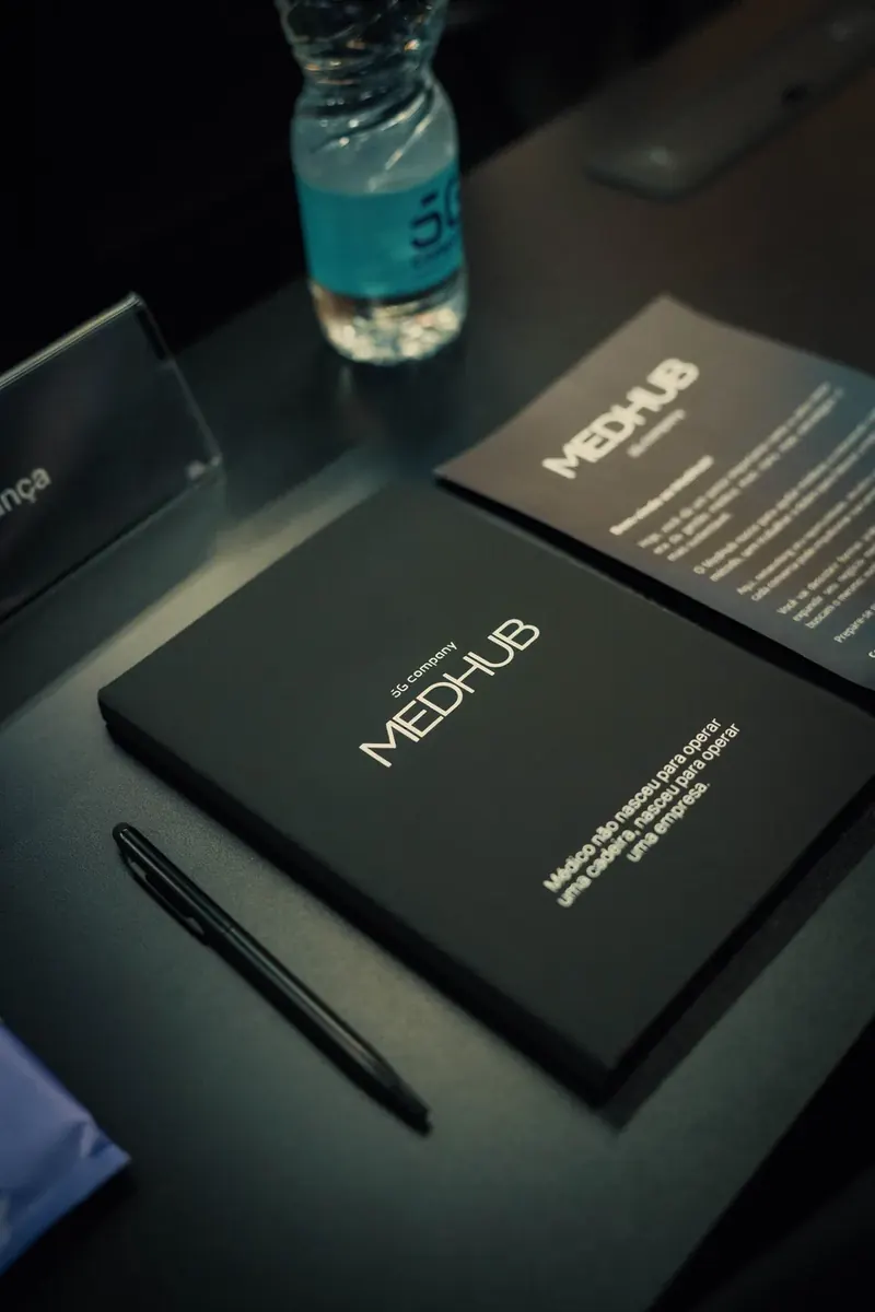 Caderno do MedHub sobre a mesa com a frase: médico não nasceu para operar uma cadeira, nasceu para operar uma empresa